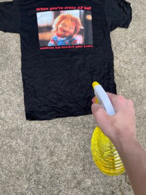 Spraying crazy AF Chucky t shirt for bleach tie dye