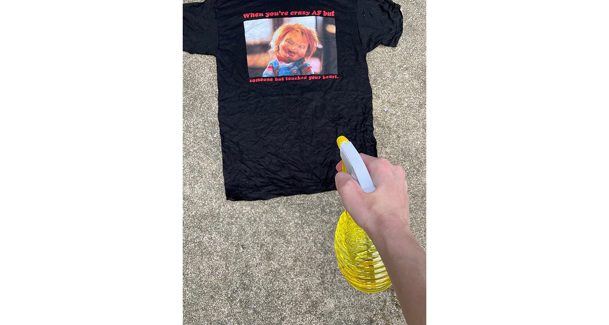 Spraying crazy AF Chucky t shirt for bleach tie dye